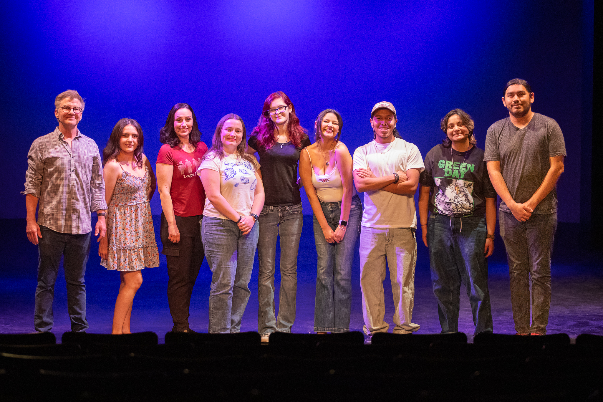A group of students stand in a row on stage
